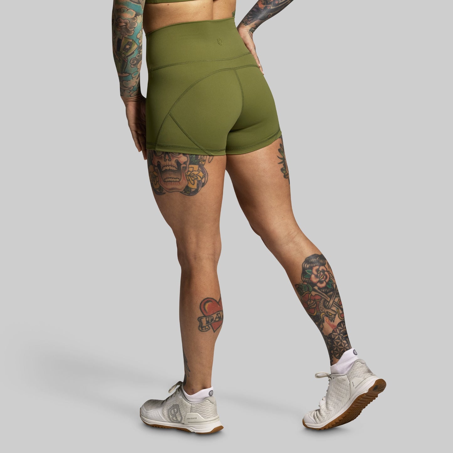 Person wearing green athletic shorts on a gray background