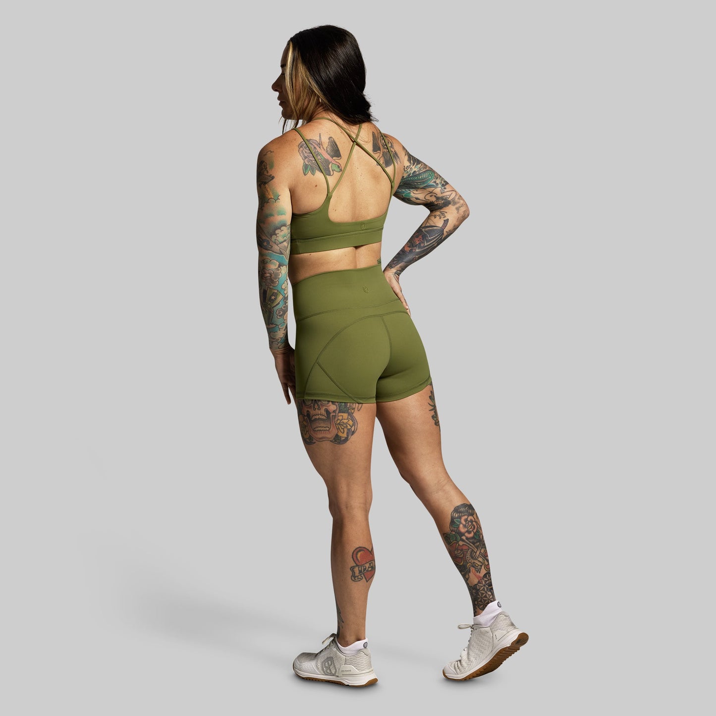 Person wearing a green athletic outfit on a gray background
