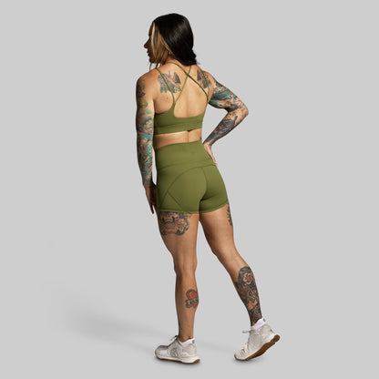 Person wearing a green athletic outfit on a gray background