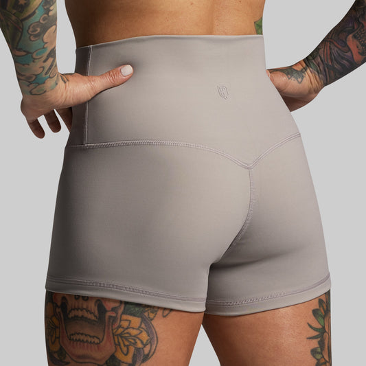 Person wearing gray athletic shorts with a plain background