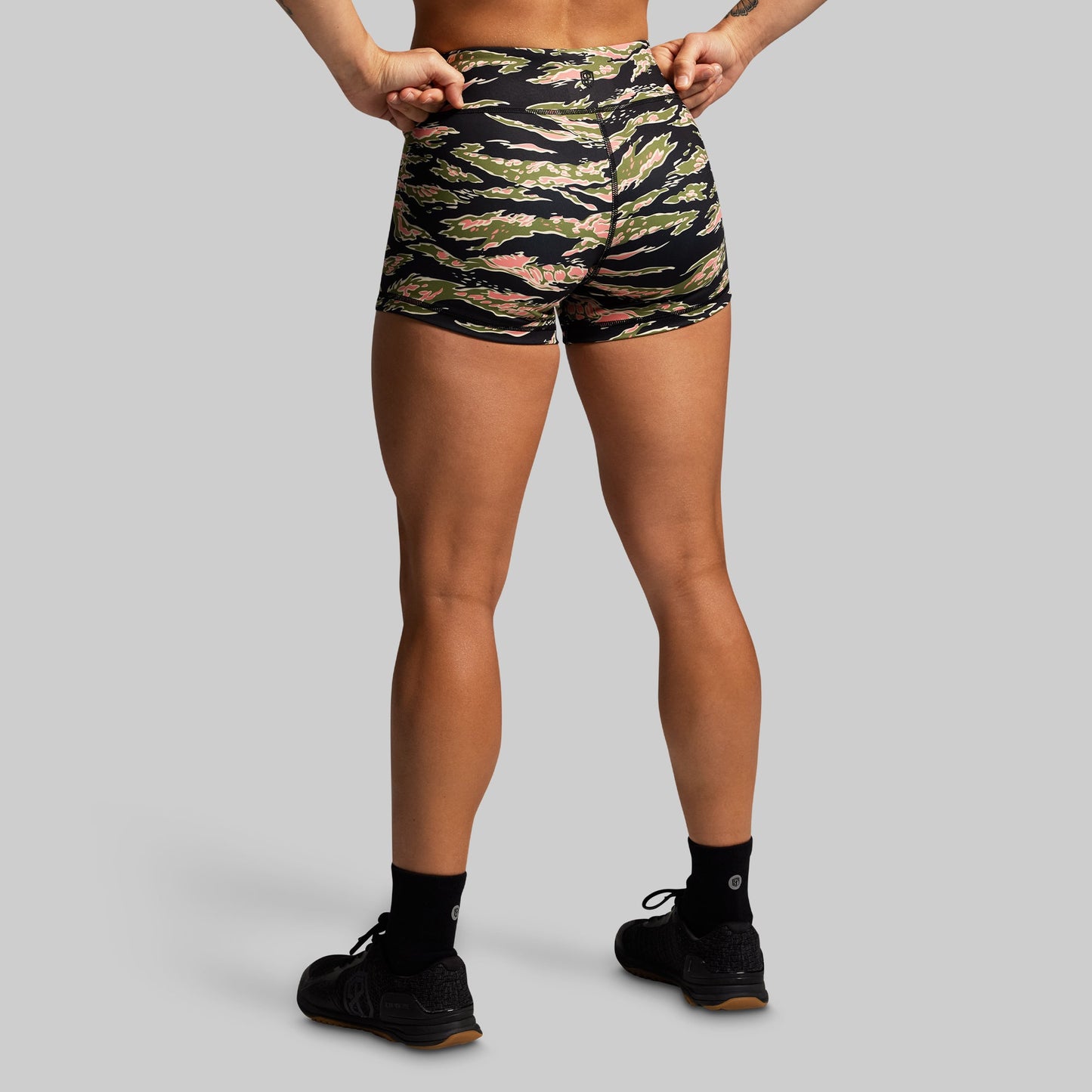 Person wearing camouflage shorts on a gray background