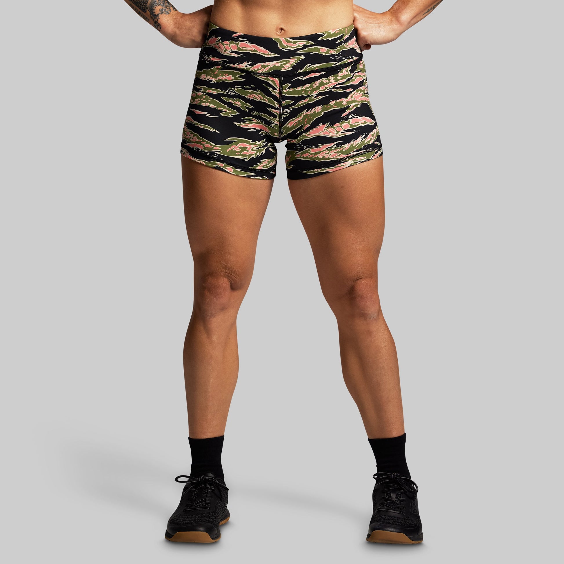 Person wearing camouflage shorts on a gray background