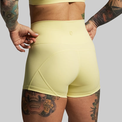 Person wearing light green athletic shorts on a gray background