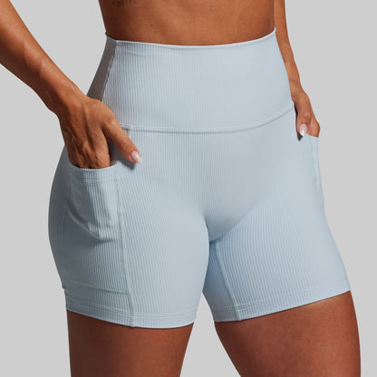 Light blue athletic shorts worn by a person on a gray background
