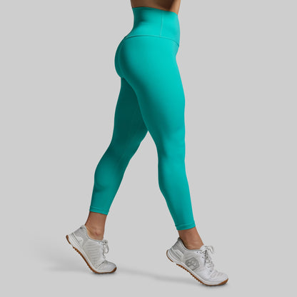 Teal leggings worn by a person on a gray background