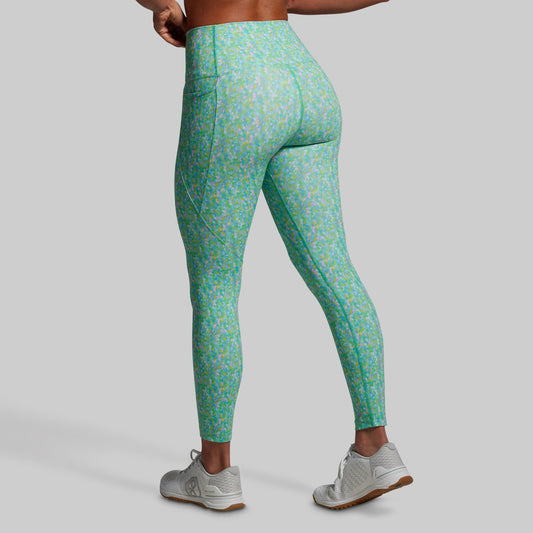 Green patterned leggings worn by a person on a gray background