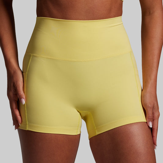 Yellow athletic shorts worn by a person on a gray background