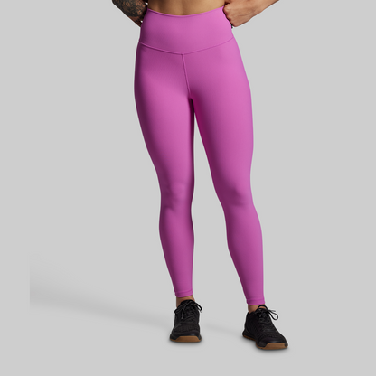 Person wearing bright pink leggings on a plain background