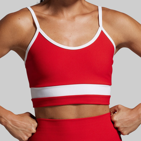 Red sports bra and leggings set on a neutral background