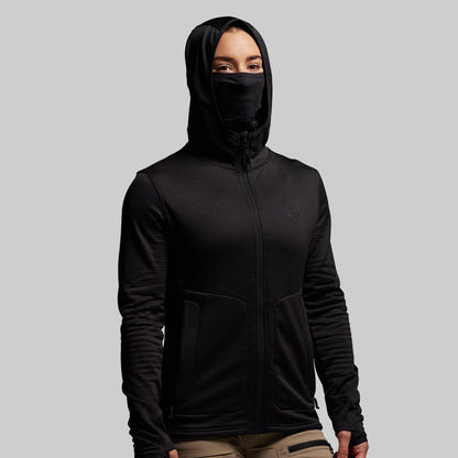 Person wearing a black hoodie with a built in face mask on a gray background