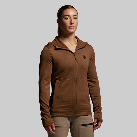 Woman wearing a brown hoodie with a logo on a gray background