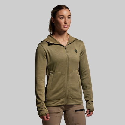 Woman wearing a green hoodie with a logo on a gray background