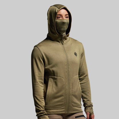Person wearing a green hoodie with a face mask on a gray background