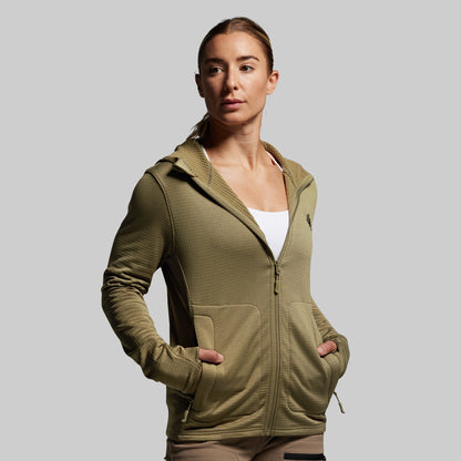 Woman wearing a green hoodie against a gray background