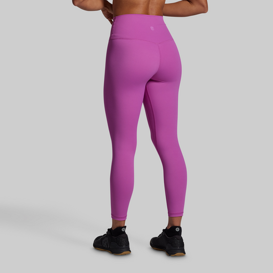 Person wearing bright pink leggings on a gray background