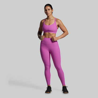 Woman wearing a pink athletic outfit on a gray background