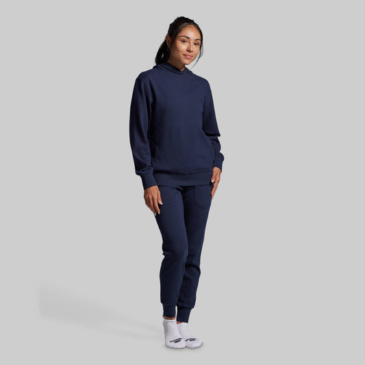 Person wearing a navy blue tracksuit on a gray background