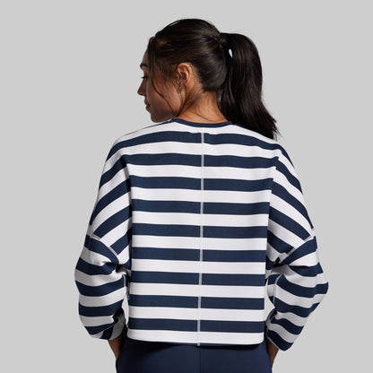 Person wearing a navy and white striped sweater on a gray background