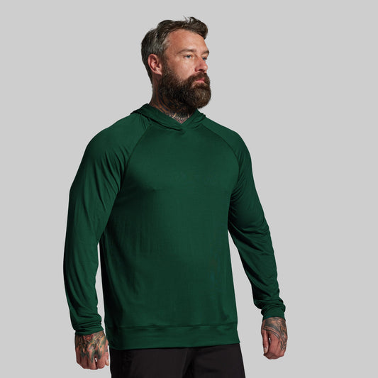 Man wearing a green hoodie against a gray background