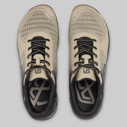 Pair of beige and black athletic shoes on a light gray background