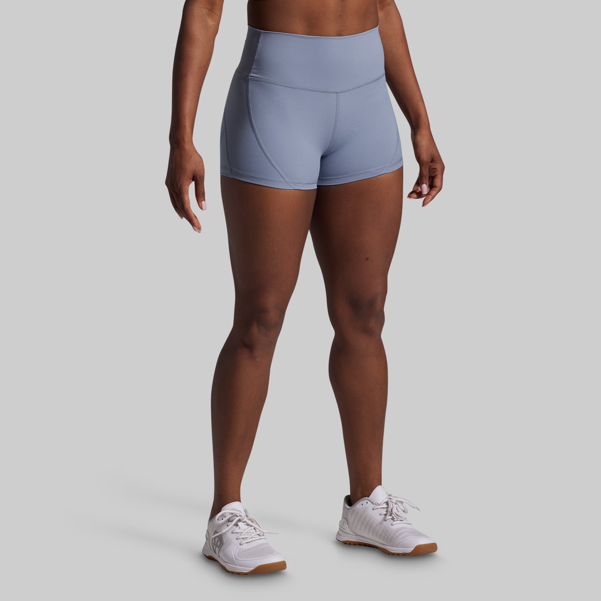 Person wearing light blue athletic shorts on a gray background
