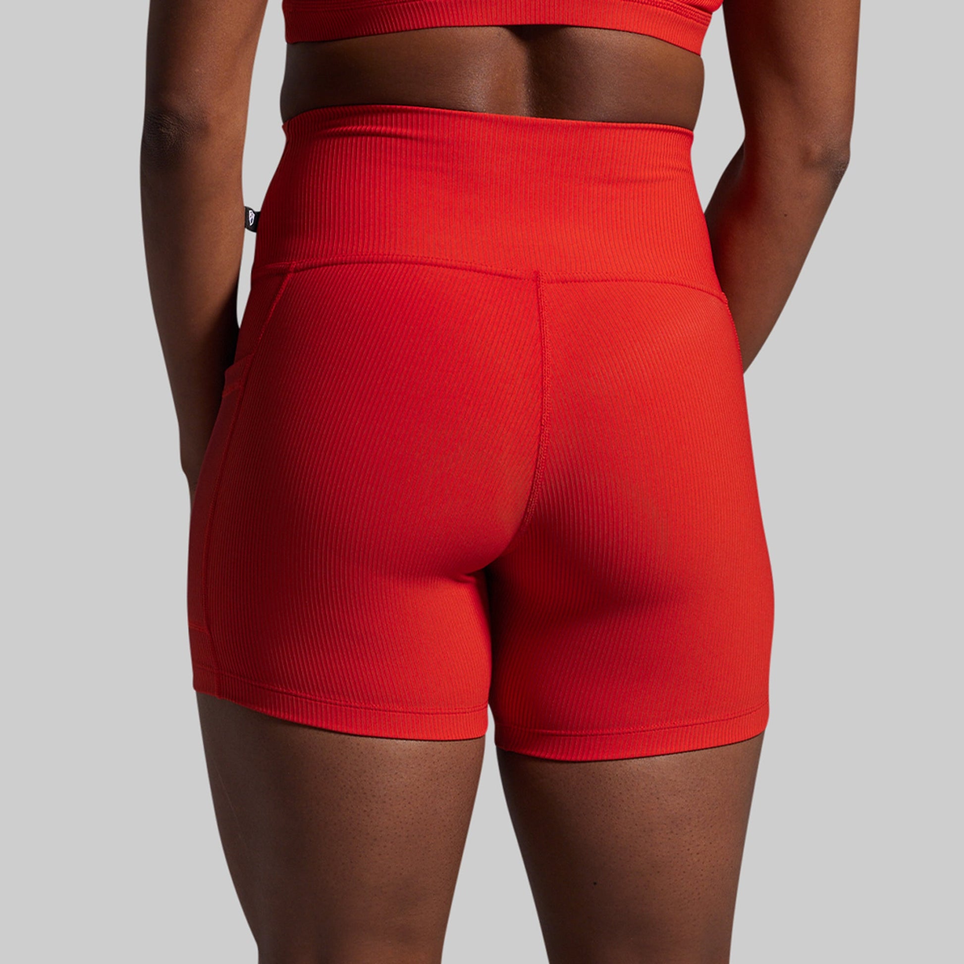 Red athletic shorts worn by a person on a gray background