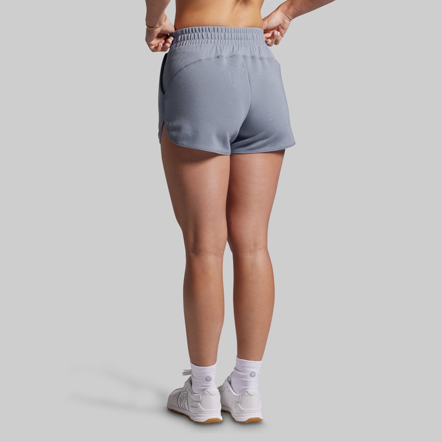 Person wearing gray lounge shorts on a plain background