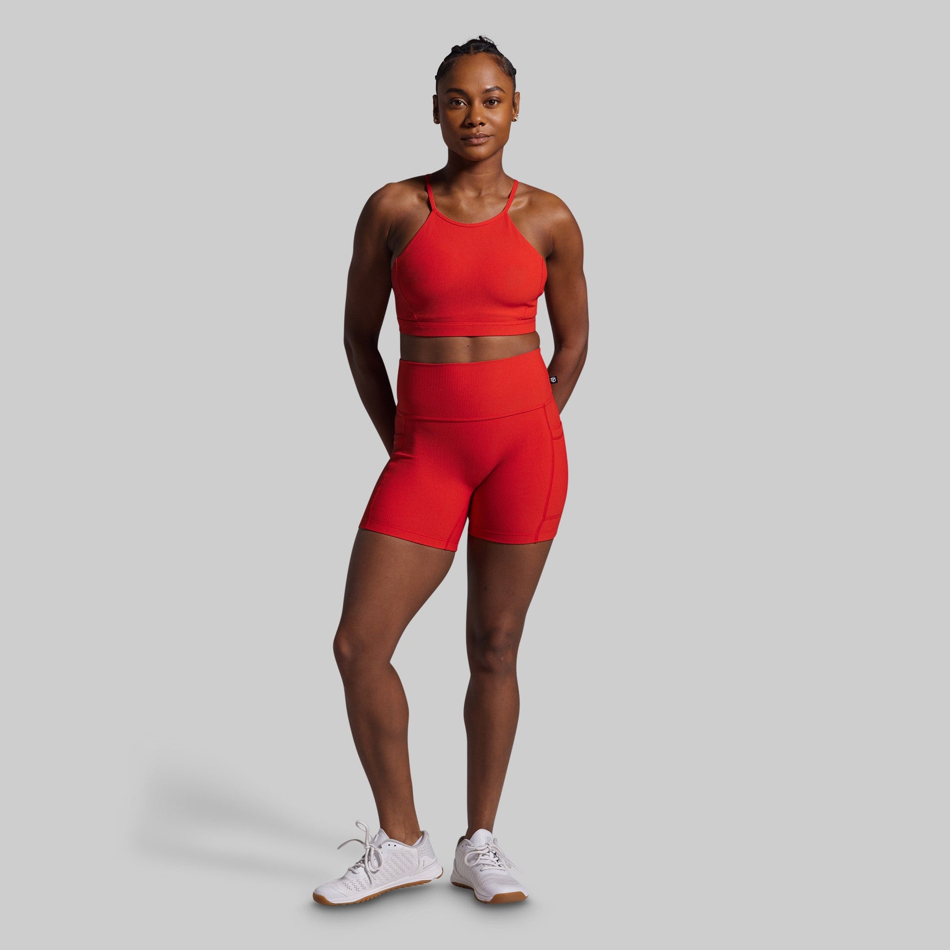 Person wearing a red athletic outfit on a gray background