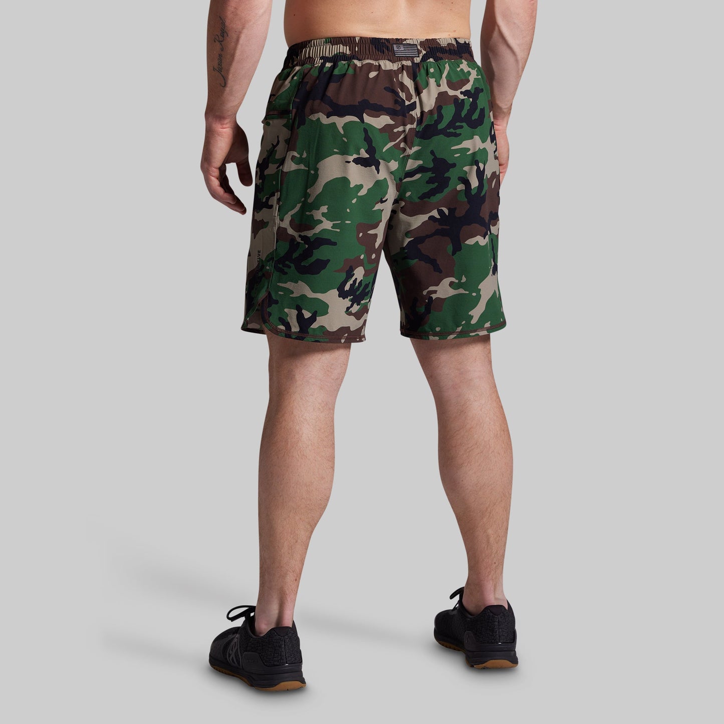 Person wearing camouflage shorts on a gray background