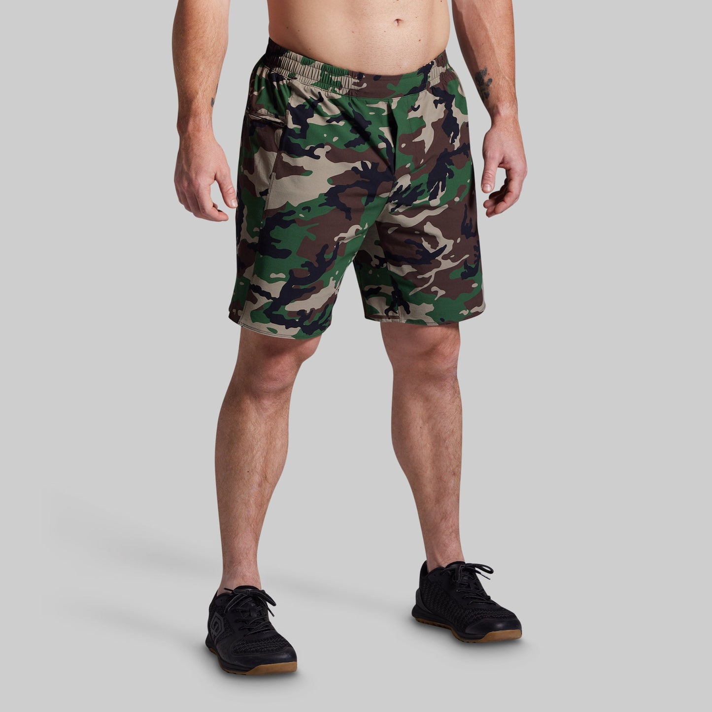 Person wearing camouflage shorts on a gray background