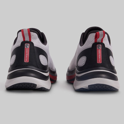 Pair of black, white, and red athletic shoes on a light gray background
