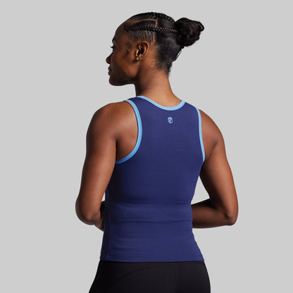 Woman wearing a blue athletic tank top on a gray background