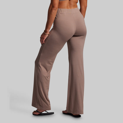 Person wearing brown wide-leg pants on a plain background