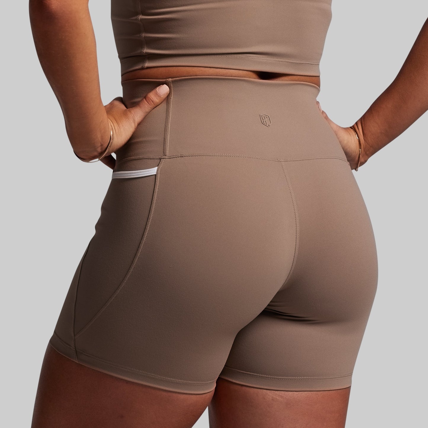 Brown athletic shorts worn by a person on a plain background
