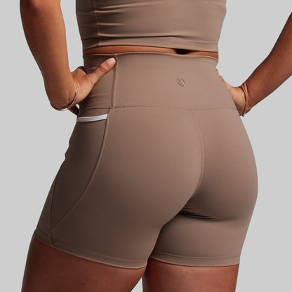 Brown athletic shorts worn by a person on a plain background