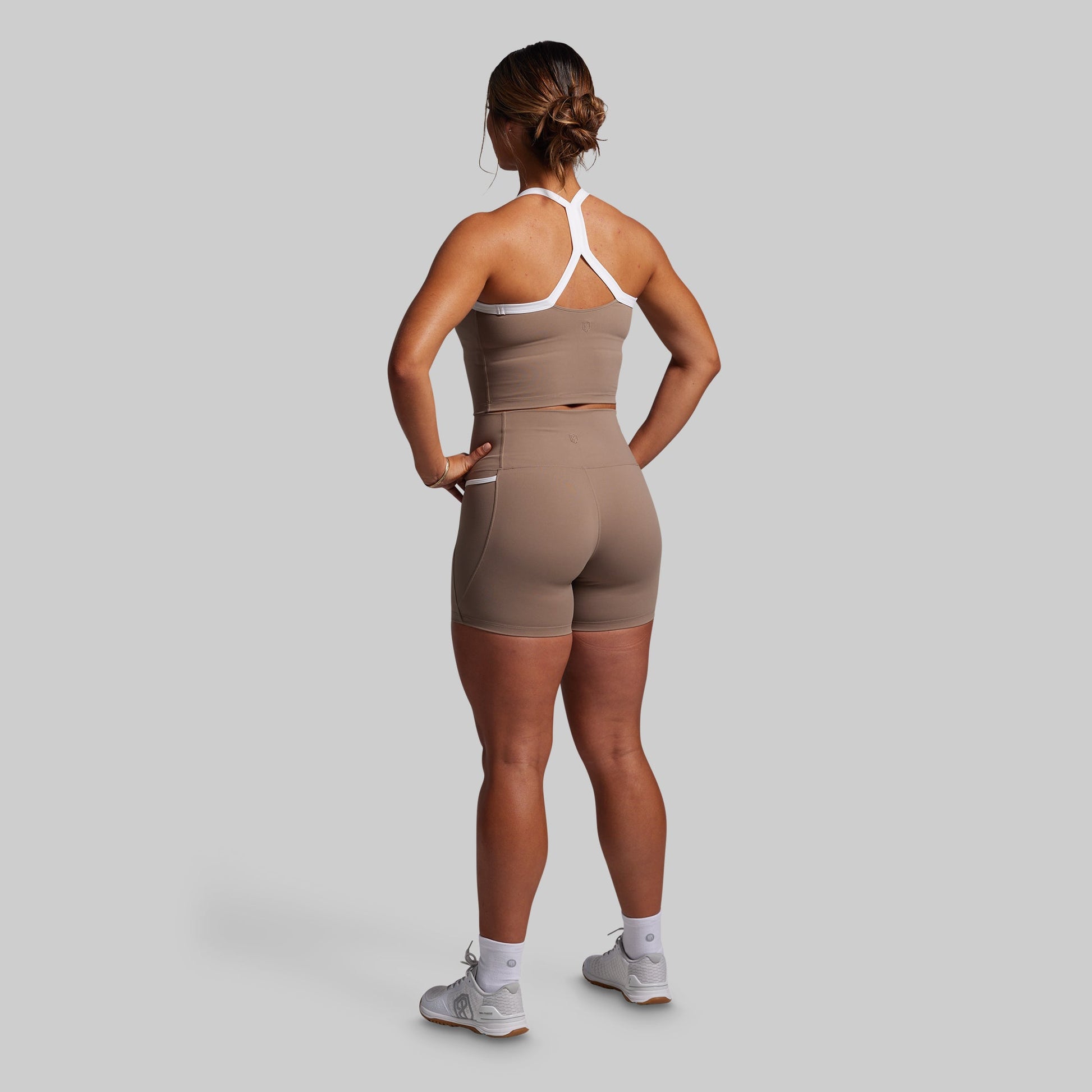 Person wearing a brown sports outfit on a gray background