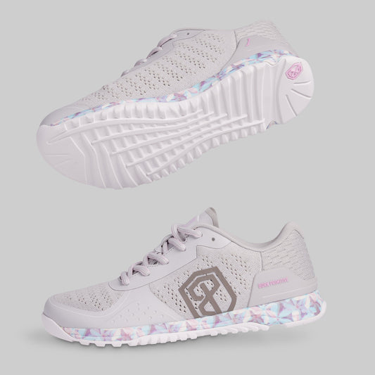 White athletic shoe with floral pattern on sole and brand logo on a light gray background