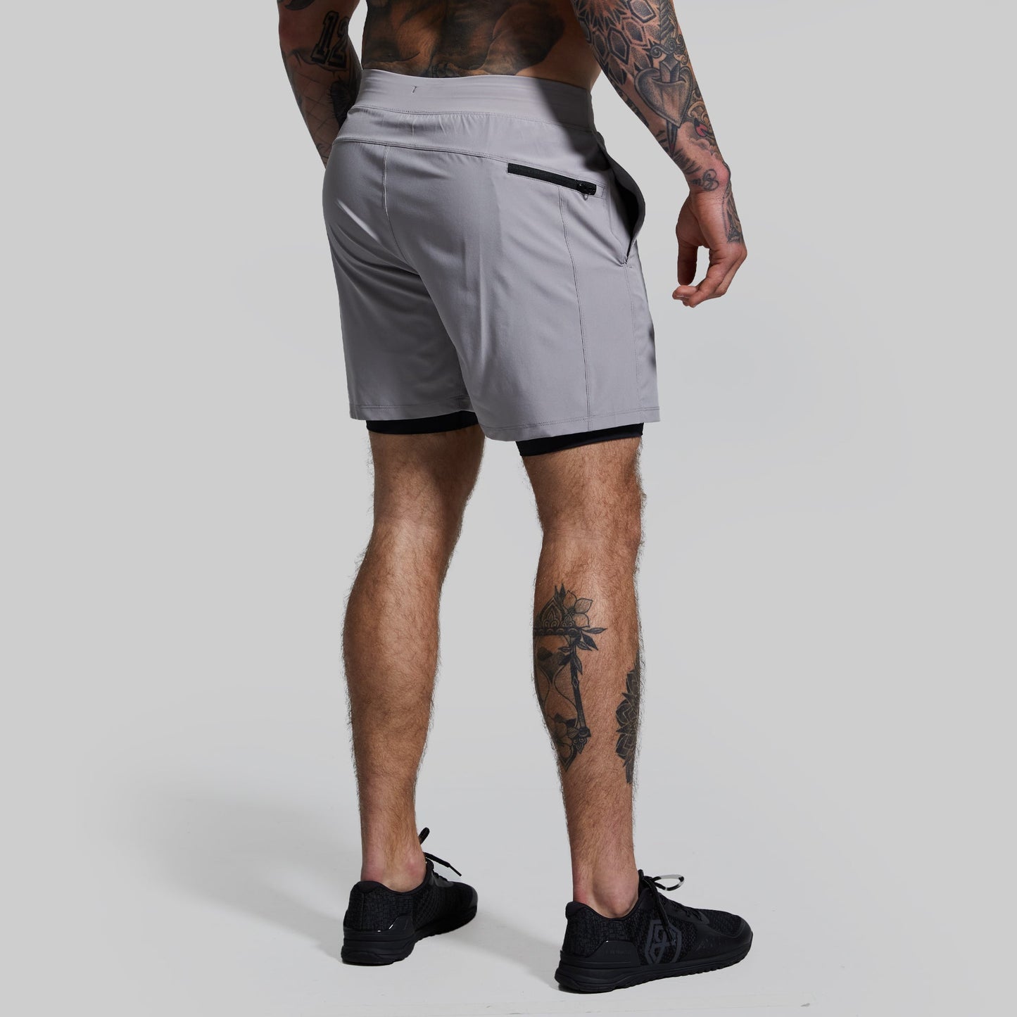 Person wearing gray athletic shorts on a plain background