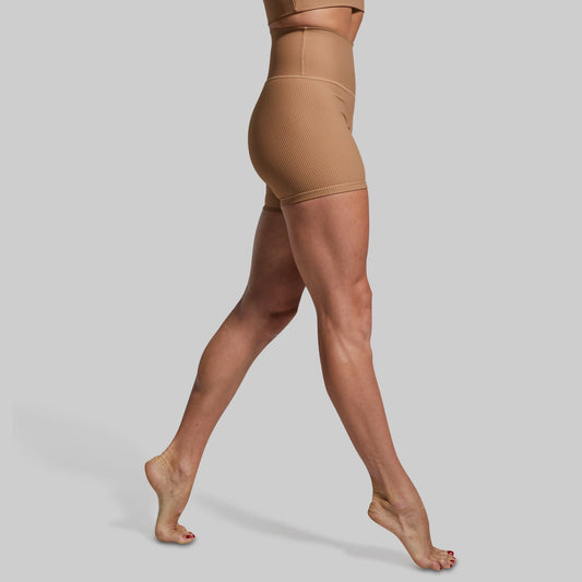 Brown ribbed shorts being worn on a plain background