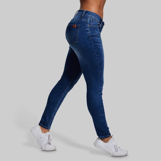 Blue jeans worn by a person on a gray background