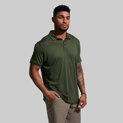 Man wearing a green polo shirt against a gray background