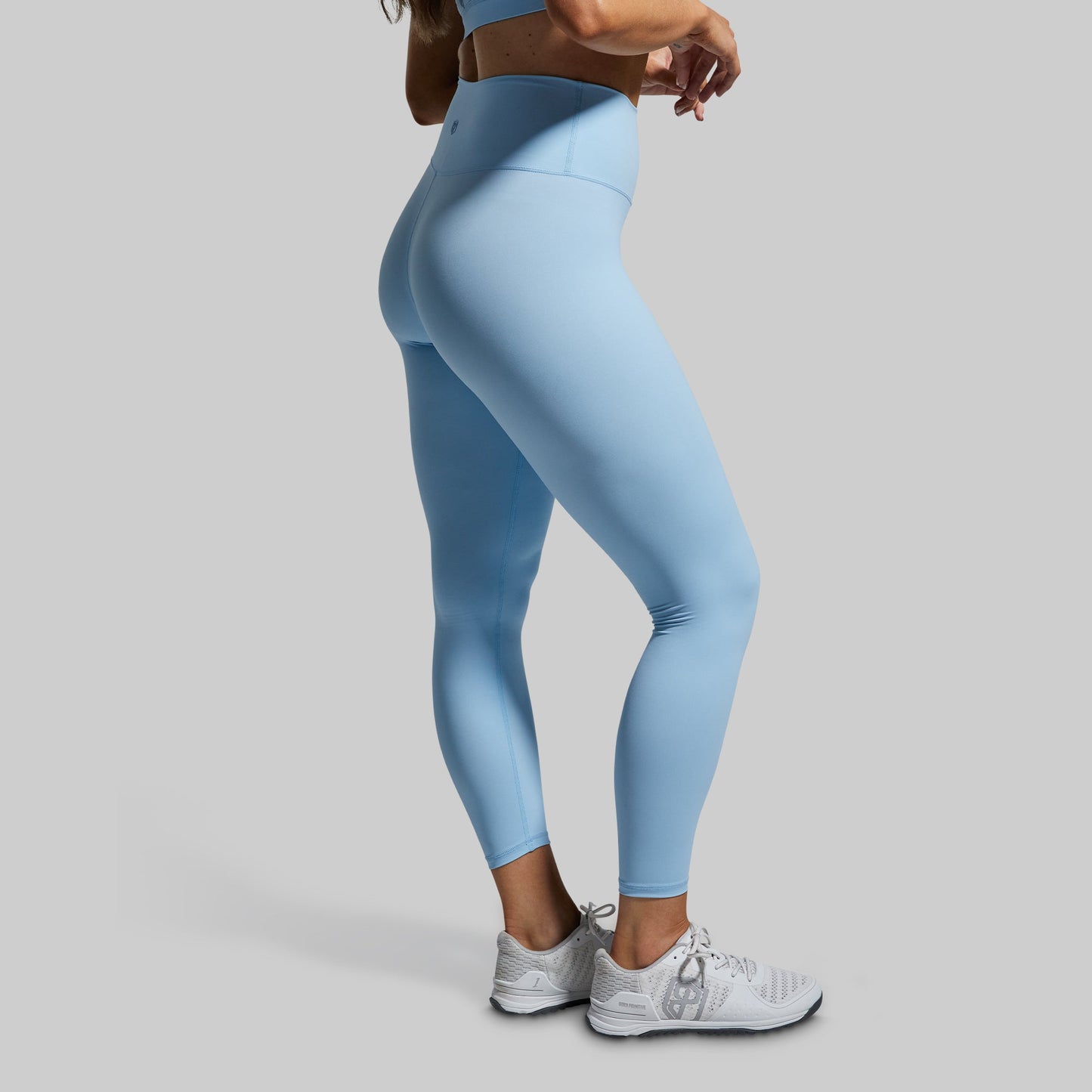 Light blue leggings worn by a person on a gray background