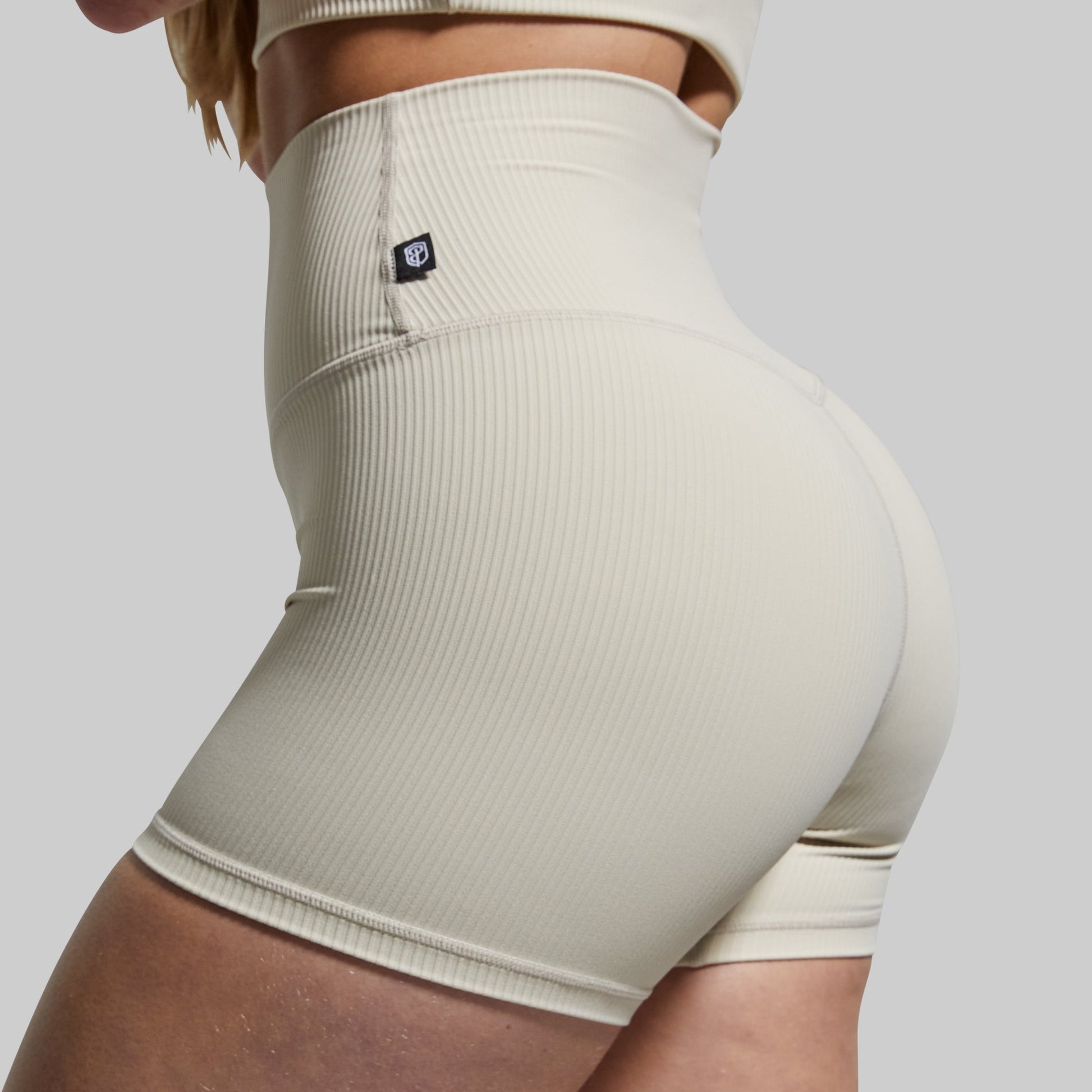 Beige ribbed high-waisted shorts on a plain background