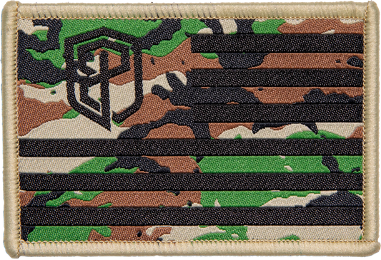 A camouflage pattern Velcro patch with the Born Primitive logo resembling an American flag design, predominantly green, black, and brown.