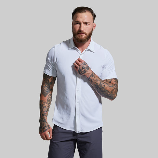 A man wearing a white short sleeve button-down shirt, with the shirt's collar visible and buttoned.